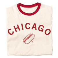 A folded off white ringer t-shirt with red accents and curved red ink text that says, "Chicago" over an illustration of a Chicago style hot dog.