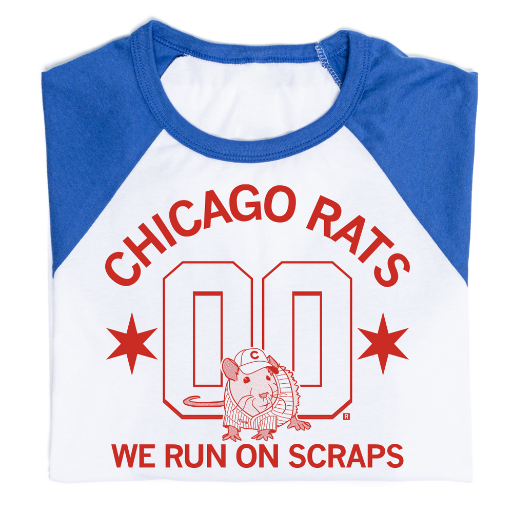 A folded white baseball tee with blue sleeves and collar and bright red ink that reads "Chicago Rats we run on scraps" with an illustration of a rat in a baseball uniform sitting in front of two large zeroes.