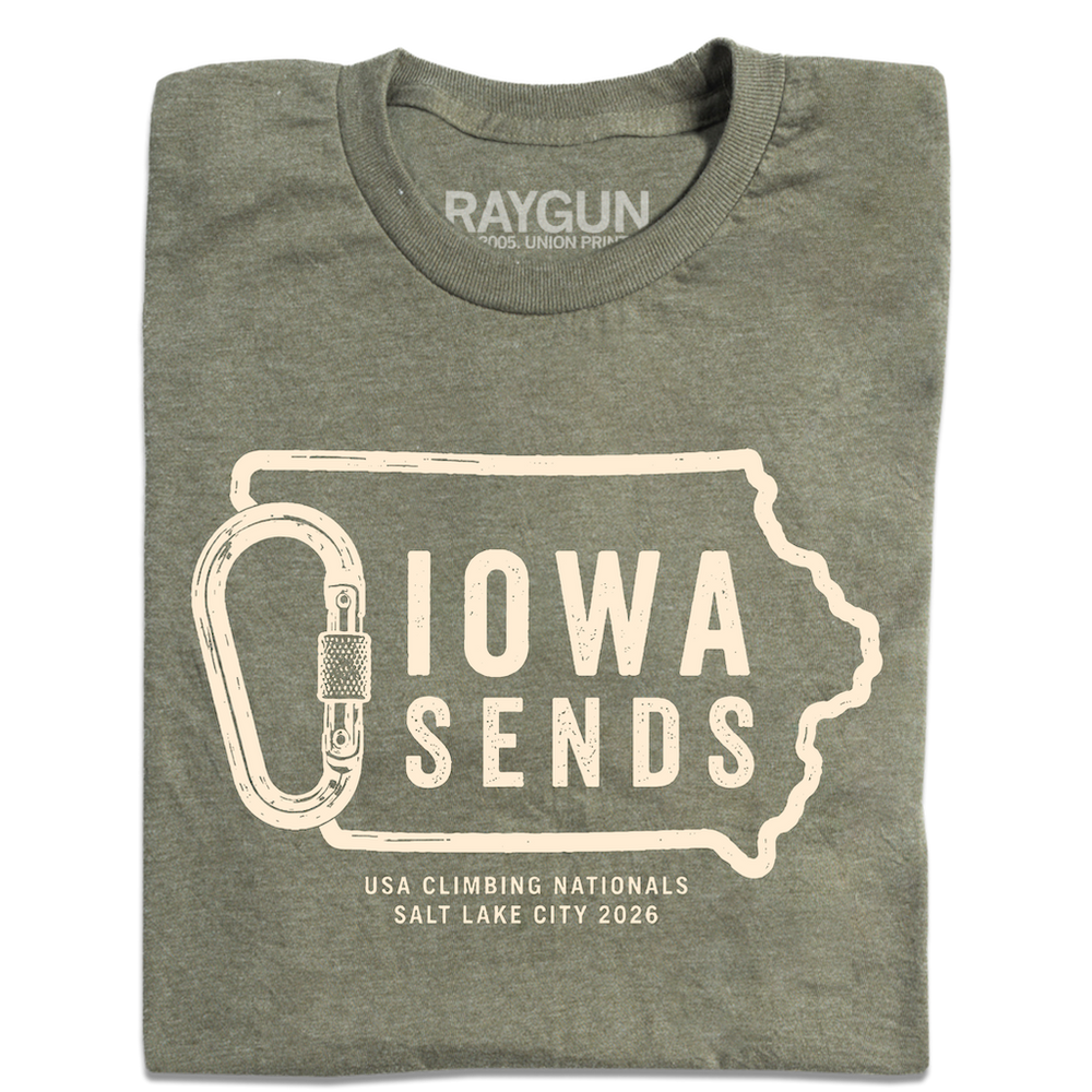A folded heather military green t-shirt with off white ink showing an outline of Iowa with it's western border being a carabiner. Large text inside the state outline says, "Iowa sends" and smaller text below reads "US Climbing Nationals. Salt Lake City 2026"