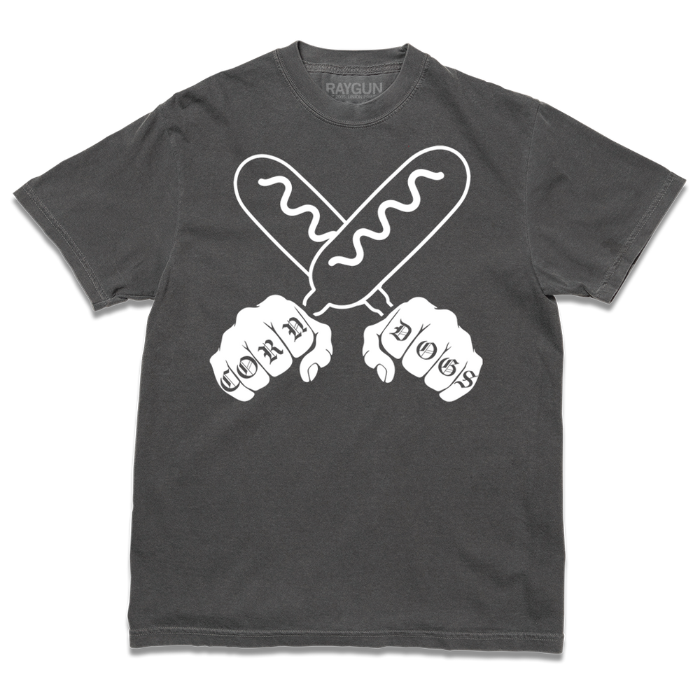 A comfort colors heavyweight dark grey t-shirt with a white print illustration of two hands holding corndogs in an X shape with knuckle tattoos that spell out "CORNDOGS."