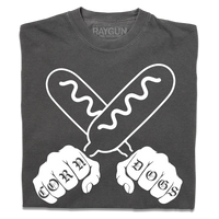 A folded grey t-shirt with a white print illustration of two hands holding corndogs in an X shape with knuckle tattoos that spell out "CORNDOGS."