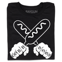 A folded black t-shirt with a white print illustration of two hands holding corndogs in an X shape with knuckle tattoos that spell out "CORNDOGS."