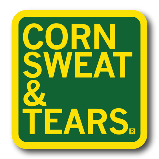 A square green sticker with rounded corners, a yellow border, and yellow text that says, "Corn Sweat & Tears"