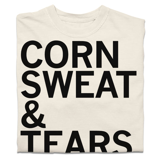 A folded off-white t-shirt with black text that says, "corn sweat & tears."