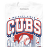 A folded white t-shirt with red and blue print. The center depicts Chicago's skyline with a large baseball peaking out from behind it. Text from top to bottom reads "Wrigley Field. Cubs. Chicago. Since 1870. Fly The W."