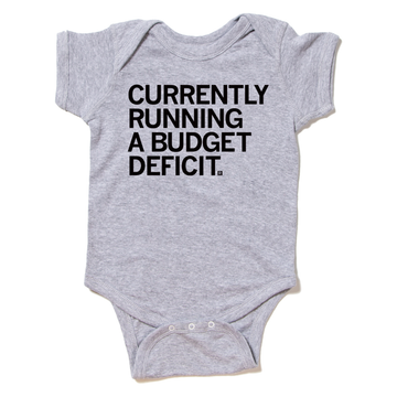 Grey union made baby onesie with the text CURRENTLY RUNNING A BUDGET DEFICIT printed in black.