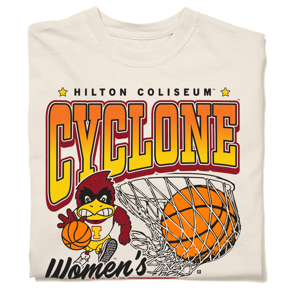 A folded comfort colors ivory heavyweight t-shirt with black, red, orange, and gold ink. From top to bottom it reads "Hilton Coliseum. Cyclone Women's Basketball. Established 1973." With an illustration of Cy dribbling a basketball beside a giant basketball going through a hoop.