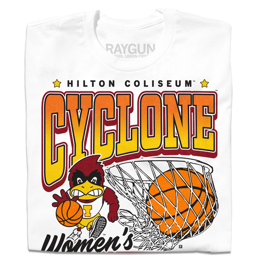 A folded white t-shirt with black, red, orange, and gold ink. From top to bottom it reads "Hilton Coliseum. Cyclone Women's Basketball. Established 1973." With an illustration of Cy dribbling a basketball beside a giant basketball going through a hoop.