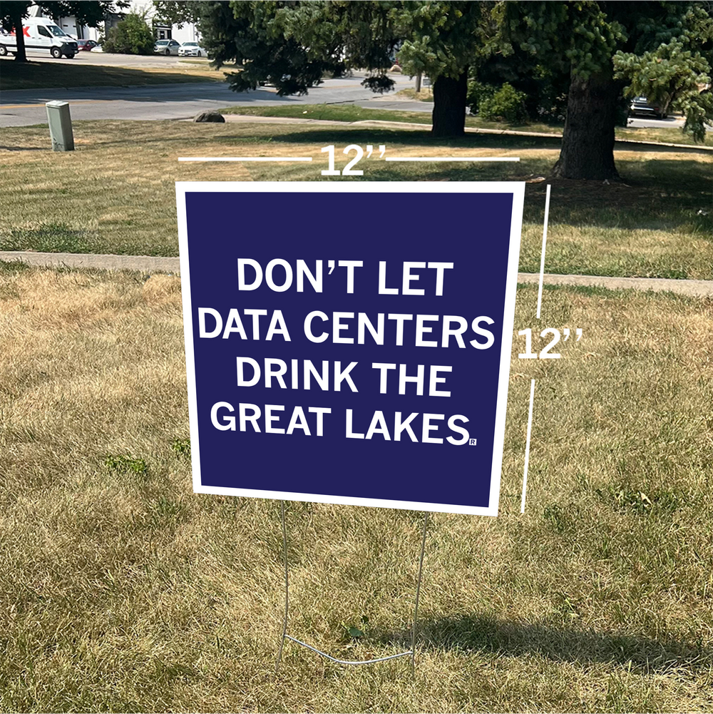 A square dark blue yard sign with a white border and white text that reads "Don't Let Data Centers Drink The Great Lakes" shown on a lawn.