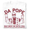 White union-made t-shirt featuring a red line-art illustration of a person wearing sunglasses and a star-covered vest, with the text DA POPE, MAY BEEF BE WITH YOU, and WATER INTO OLD STYLE, STONES INTO DEEP DISH.