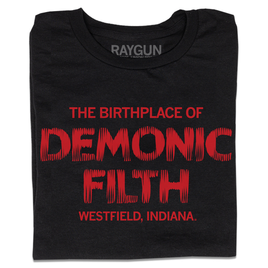 A folded black t-shirt with bright red ink in horror movie font that reads "The birthplace of demonic filth Westfield, Indiana."