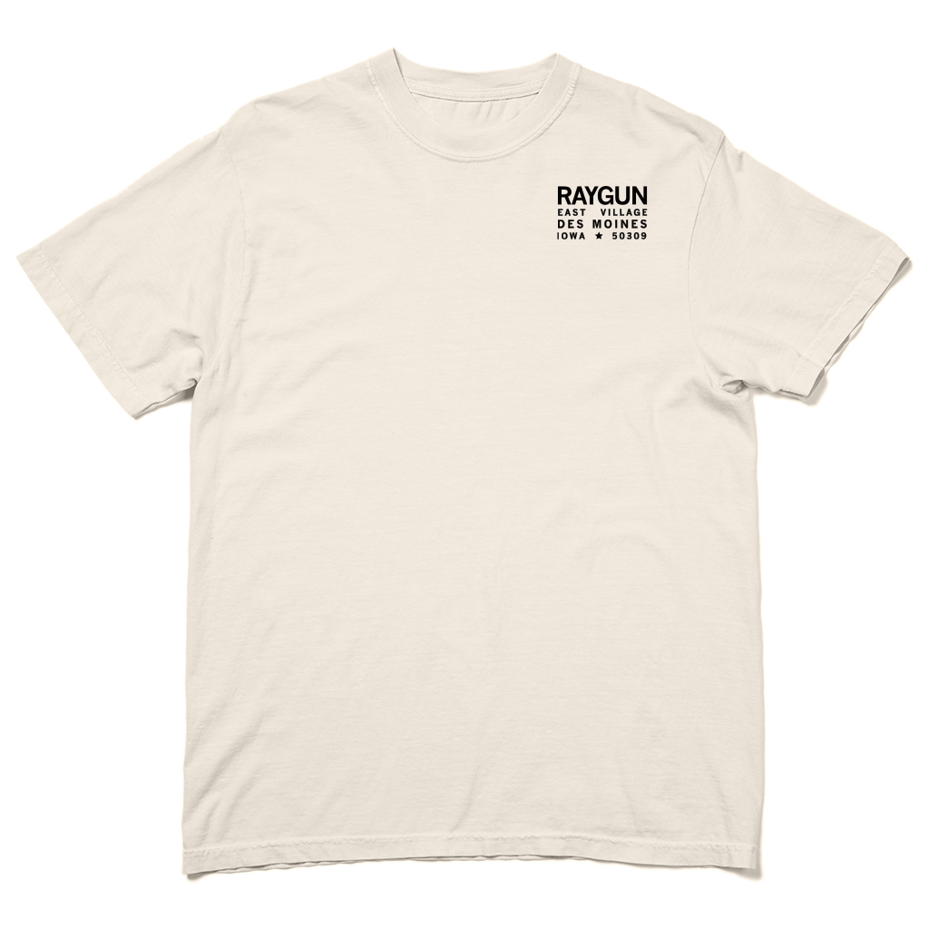 Off-white, garment-dyed heavyweight cotton t-shirt with a small RAYGUN EAST VILLAGE DES MOINES IOWA 50309 logo printed on the chest.