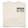 Off-white, garment-dyed heavyweight cotton t-shirt with black text on the chest that reads RAYGUN EAST VILLAGE DES MOINES IOWA 50309.