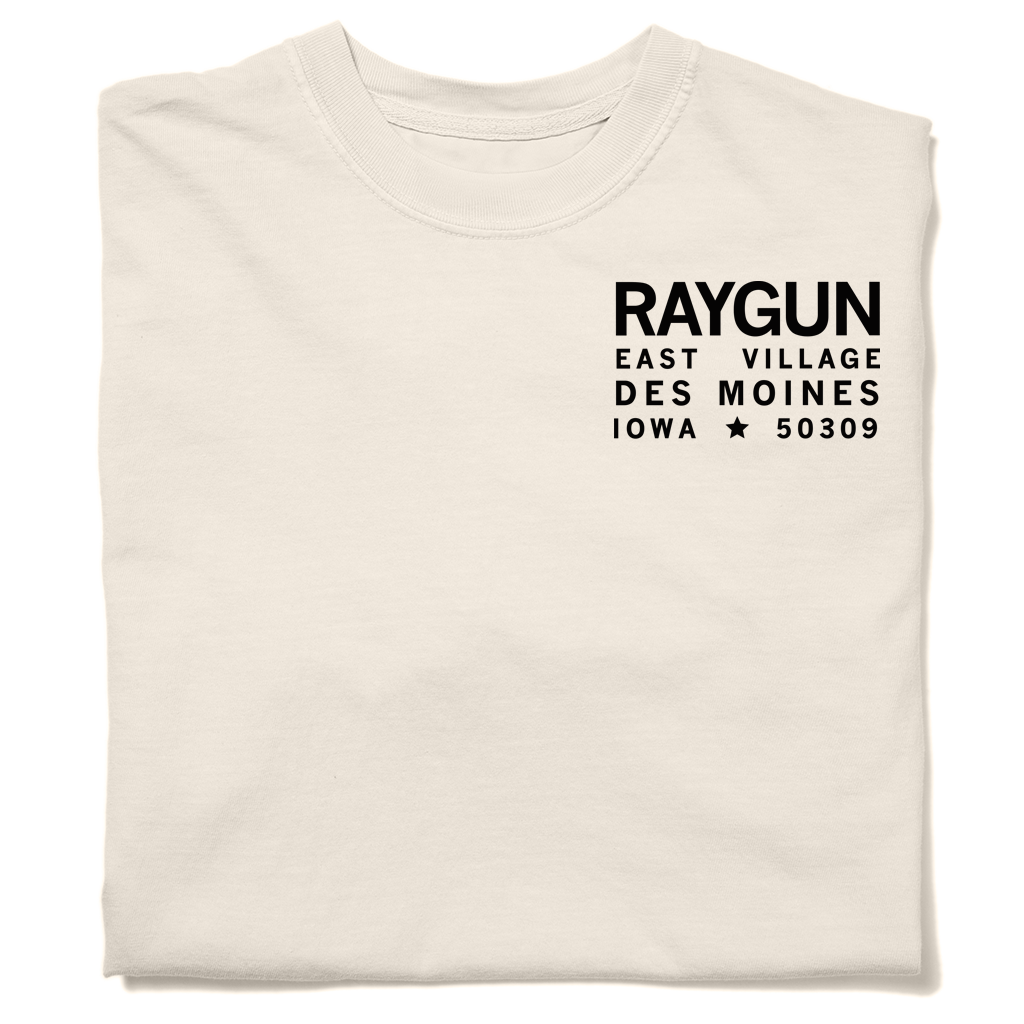 Off-white, garment-dyed heavyweight cotton t-shirt with black text on the chest that reads RAYGUN EAST VILLAGE DES MOINES IOWA 50309.