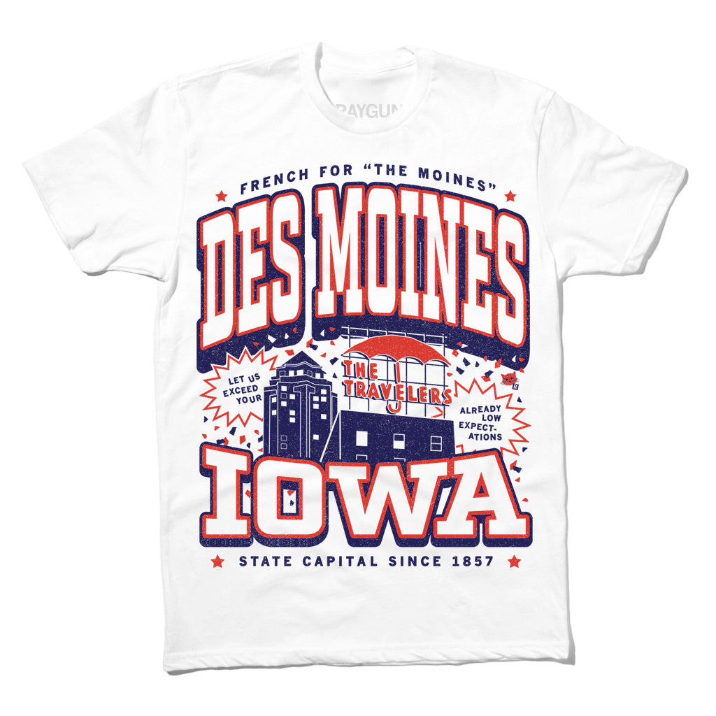 White RAYGUN t-shirt featuring a Des Moines graphic with the Travelers Insurance building and the slogans Let us exceed your low expectations and French for The Moines.