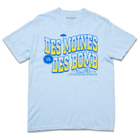 Comfort Colors heavyweight light blue t-shirt with bright gold and blue ink text that reads "Des Moines is Des Bomb. Let us exceed your already low expectations" with a small Des Moines skyline in the bottom right.