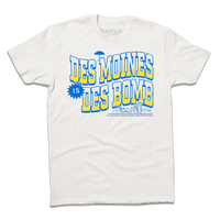 White t-shirt with bright gold and blue ink text that reads "Des Moines is Des Bomb. Let us exceed your already low expectations" with a small Des Moines skyline in the bottom right.