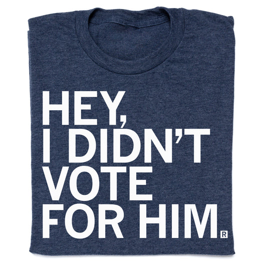 A blue RAYGUN t-shirt featuring white text that reads, HEY, I DIDNT VOTE FOR HIM.