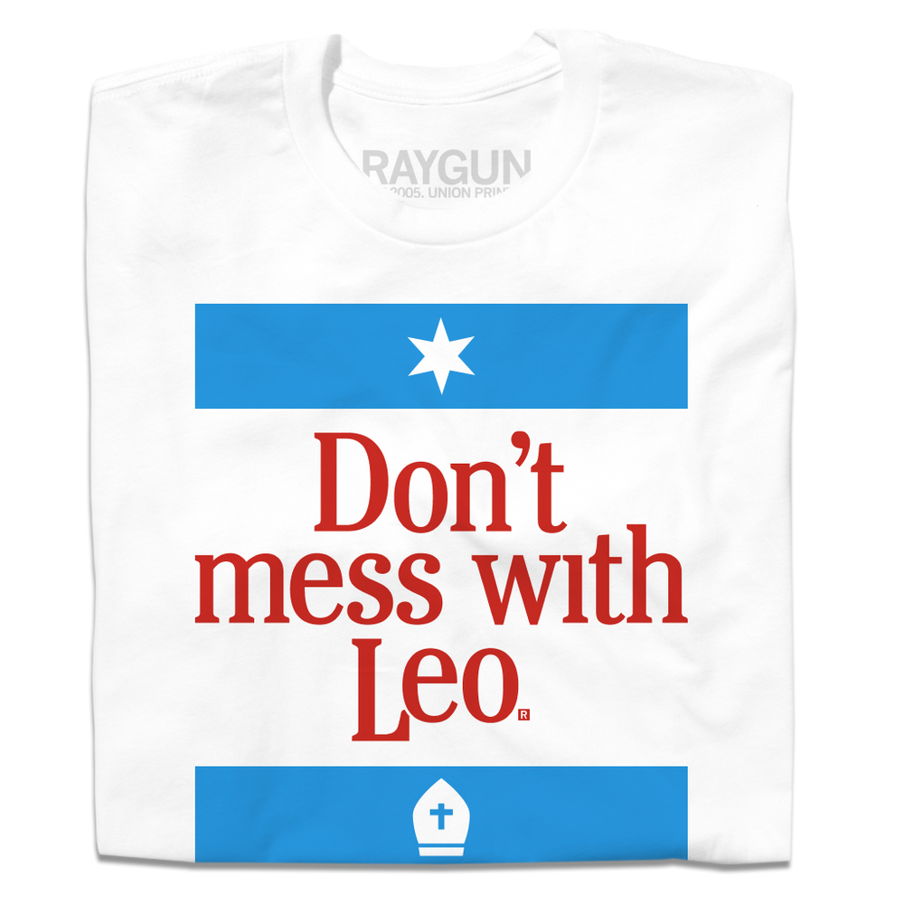 A folded white t-shirt with blue and red ink lade out like a blend of the Texas and Chicago flag that says, "Don't mess with Pope Leo."