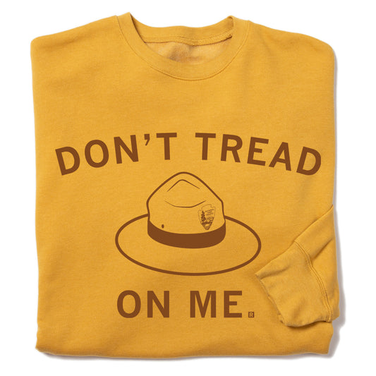 Mustard-yellow RAYGUN sweatshirt featuring brown text that reads DONT TREAD ON ME above a graphic of a National Park Service ranger hat.