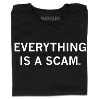 A folded black t-shirt with centered white ink text that says, "Everything is a scam."