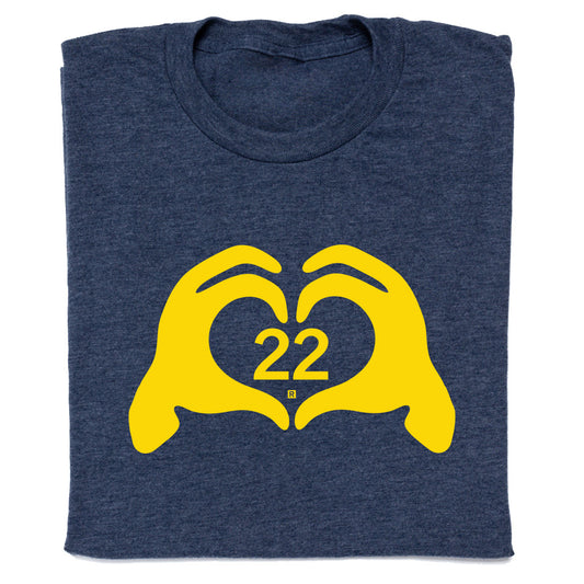Navy blue RAYGUN t-shirt with a yellow graphic of two hands forming a heart shape around the number 22.