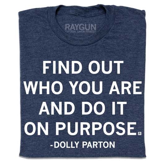 A folded heather navy t-shirt with centered white print text that says, ""Find out who you are and do it on purpose." - Dolly Parton"
