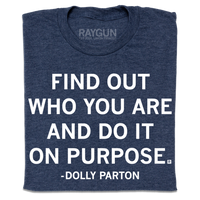 A folded heather navy t-shirt with centered white print text that says, ""Find out who you are and do it on purpose." - Dolly Parton"