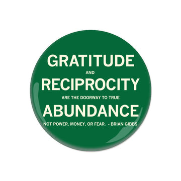 A round green gratitude button with white text that reads, Gratitude and reciprocity are the doorway to true abundance, not power, money, or fear. - Brian Gibbs.
