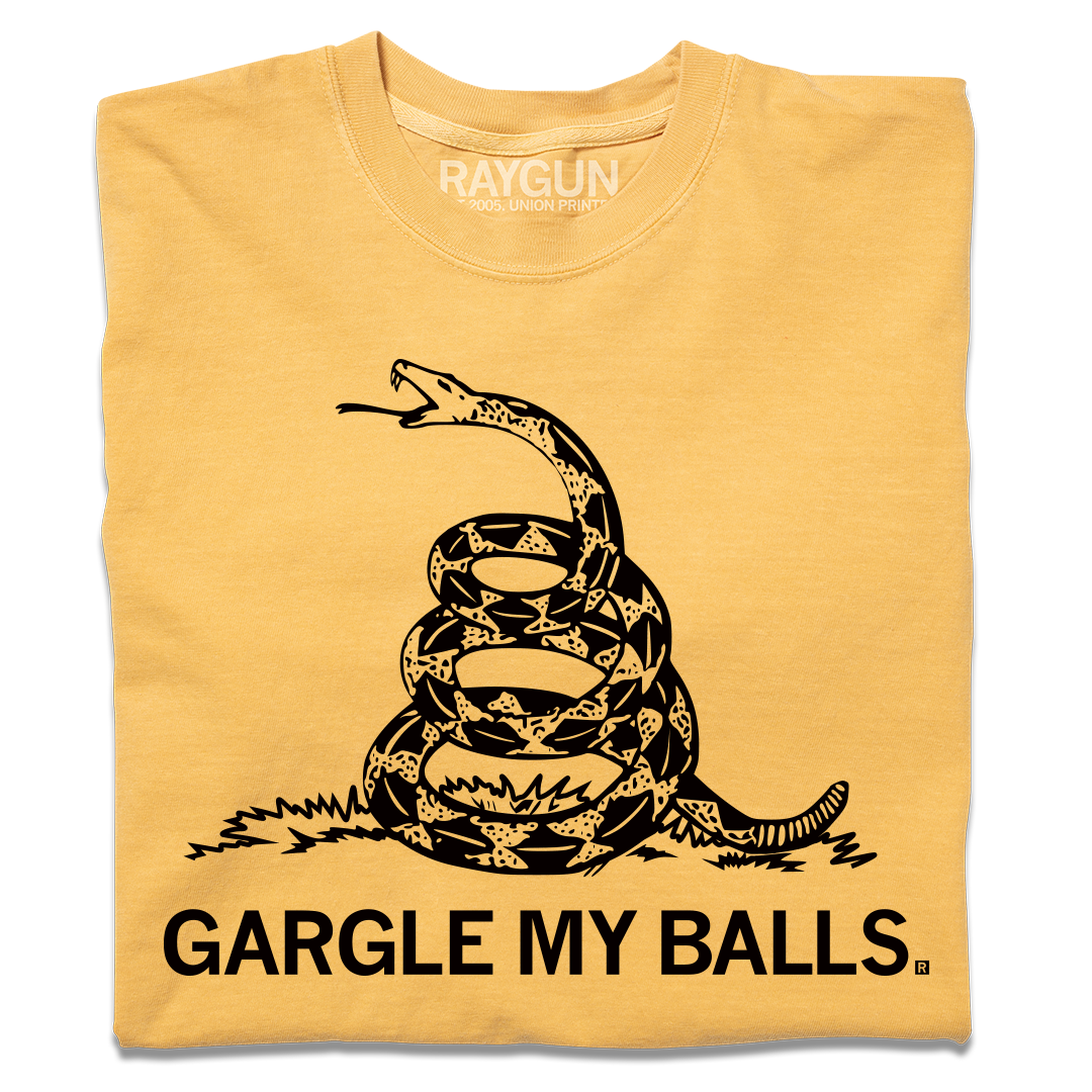 A folded heavyweight yellow t-shirt with black ink print spoofing the don't tread on me flag with "GARGLE MY BALLS" printed below the snake.