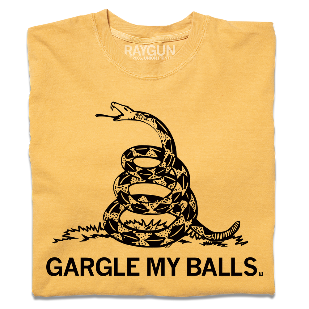 A folded heavyweight yellow t-shirt with black ink print spoofing the don't tread on me flag with "GARGLE MY BALLS" printed below the snake.