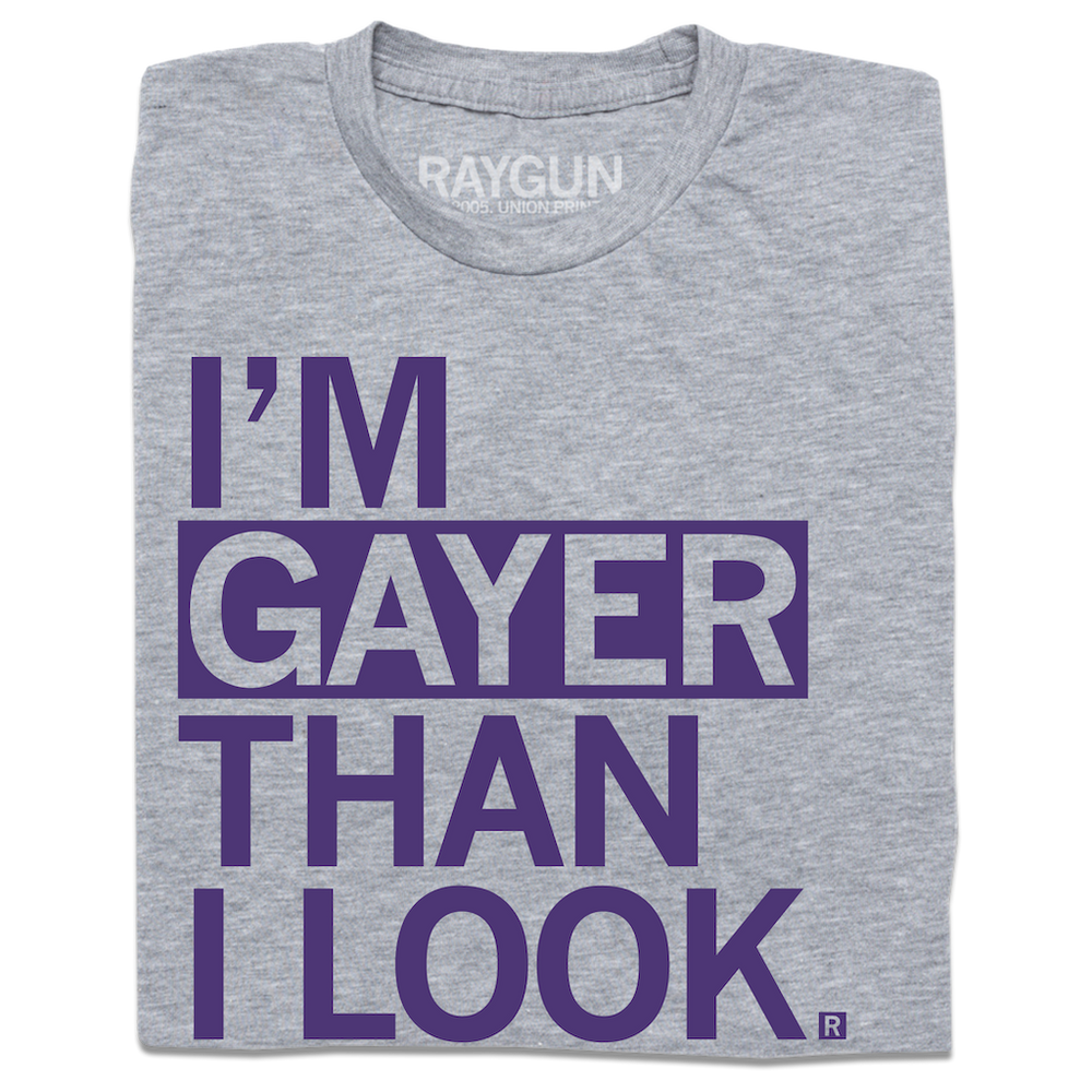A heather grey t-shirt with left aligned purple ink that reads "I'm gayer than I look."