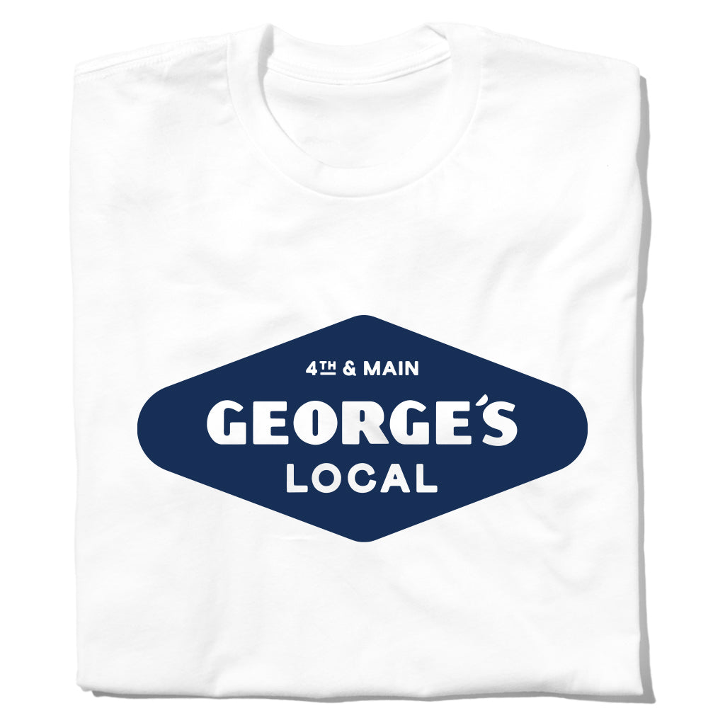 White crew neck union-made t-shirt featuring a blue diamond-shaped graphic that reads 4th & Main GEORGES LOCAL from Cedar Falls, Iowa.