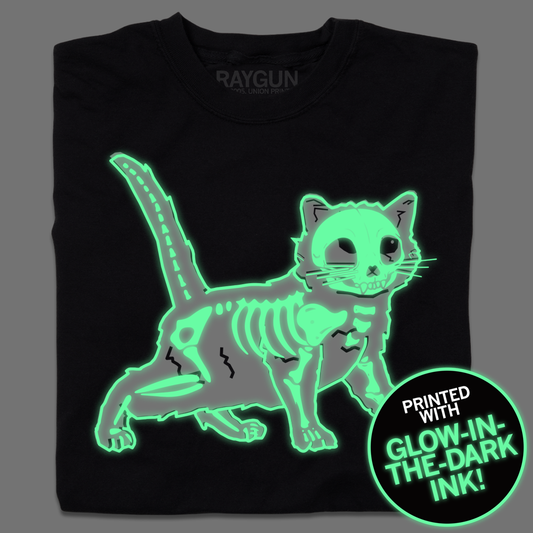 Black Gary bones t-shirt featuring a glowing green cat skeleton graphic and a circular sticker that reads, Printed with glow-in-the-dark ink!.