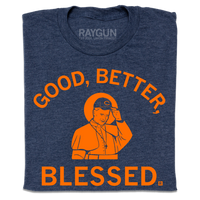 A folded heather navy t-shirt with orange print. Curved text at the top says, "Good, Better," and straight text below adds "Blessed." In the center is an illustration of Pope wearing a football team hat.