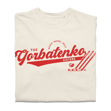 Red script text on an ivory comfort colors shirt that says, "The Gorbatenko Sissters. Nicole, Rachel, Kelly" with three hockey sticks and a puck.