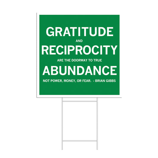 A green RAYGUN yard sign with white text that reads: GRATITUDE AND RECIPROCITY ARE THE DOORWAY TO TRUE ABUNDANCE. NOT POWER, MONEY, OR FEAR. - BRIAN GIBBS.