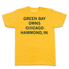 Heather mellow yellow t-shirt with centered, dark green text that says, "GREEN BAY OWNS CHICAOG HAMMOND, IN" with a line through "CHICAGO."