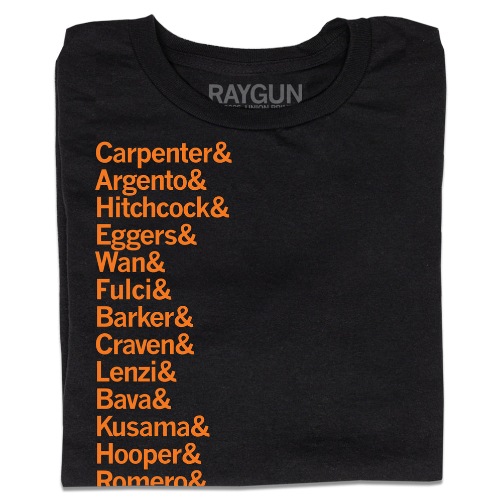 A folded black t-shirt with left-aligned orange ink that says, "Carpenter &amp; Argento &amp; Hitchcock &amp; Eggers &amp; Wan &amp; Fulci &amp; Barker &amp; Craven &amp; Lenzi &amp; Bava &amp; Kusama &amp; Hooper &amp; Romero &amp; Peele &amp; Castle &amp; Cronenberg &amp; del Toro." in a long list.