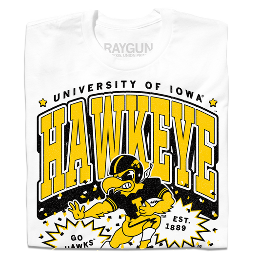 White t-shirt featuring officially licensed University of Iowa Hawkeye graphics in black and yellow, including the school mascot and EST. 1889.