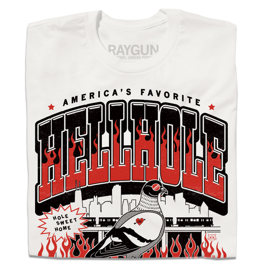 A folded white t-shirt featuring a bold graphic print with the text 'HELLHOLE' in large red and black letters, flames, a pigeon illustration, and the brand name 'RAYGUN' printed inside the collar.