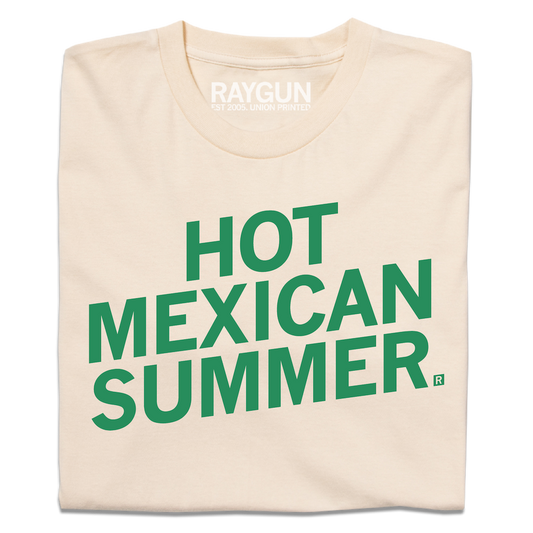 A folded cream t-shirt with slanted green ink text that says, "Hot Mexican Summer"