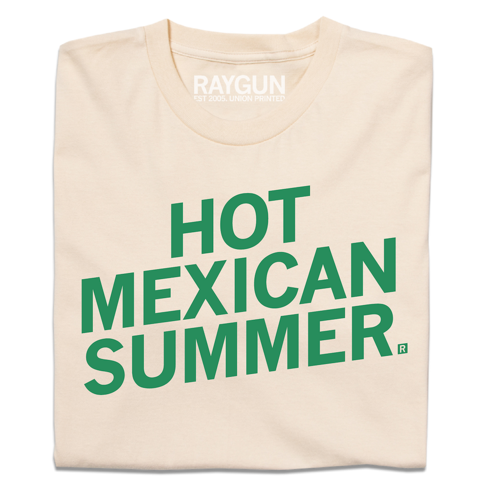 A folded cream t-shirt with slanted green ink text that says, "Hot Mexican Summer"