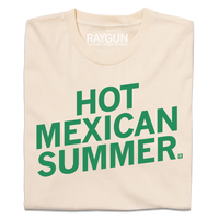 A folded cream t-shirt with slanted green ink text that says, "Hot Mexican Summer"