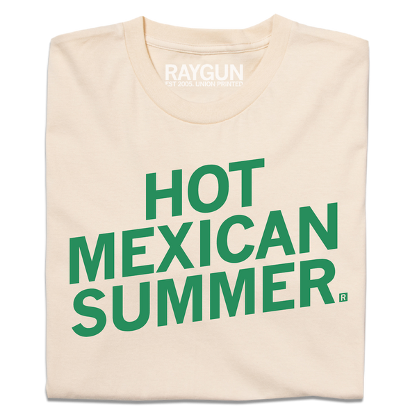A folded cream t-shirt with slanted green ink text that says, 