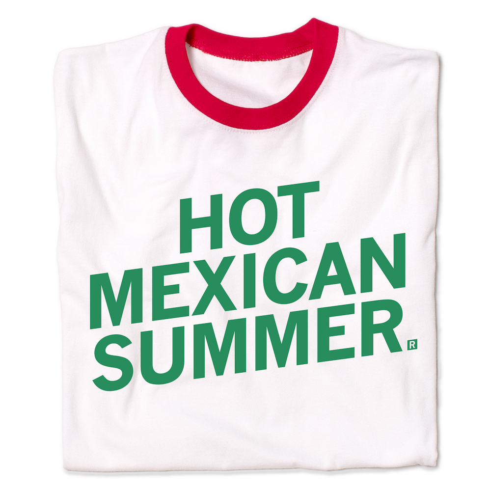 A folded white ringer shirt with red collar and red sleeve accents. Slanted green text reads "Hot Mexican Summer"