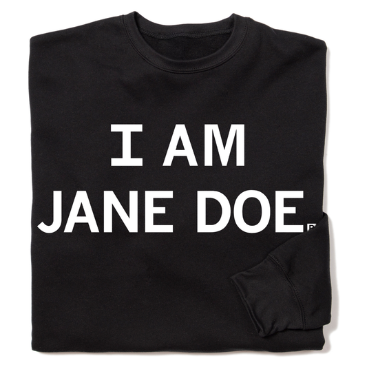 A folded black crewneck sweatshirt with centered white ink text that reads "I Am Jane Doe."