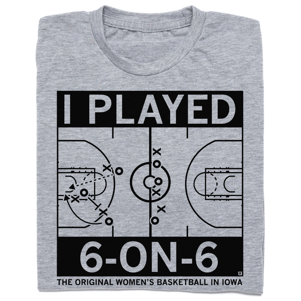 A folded heather grey t-shirt with black ink print depicting a basketball court with text that says, "I played 6-on-6. The original women's basketball in Iowa."
