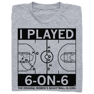 A folded heather grey t-shirt with black ink print depicting a basketball court with text that says, "I played 6-on-6. The original women's basketball in Iowa."