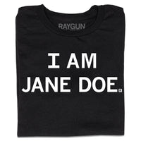A folded black t-shirt with centered white print text that says, "I Am Jane Doe" in all caps.